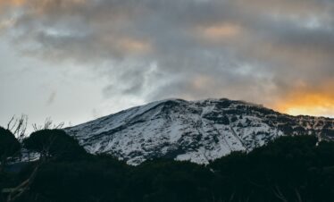 snow covered mountain under cloudy sky during daytime