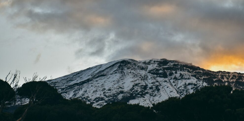 snow covered mountain under cloudy sky during daytime