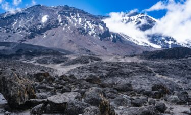 a rocky area with snow covered mountains